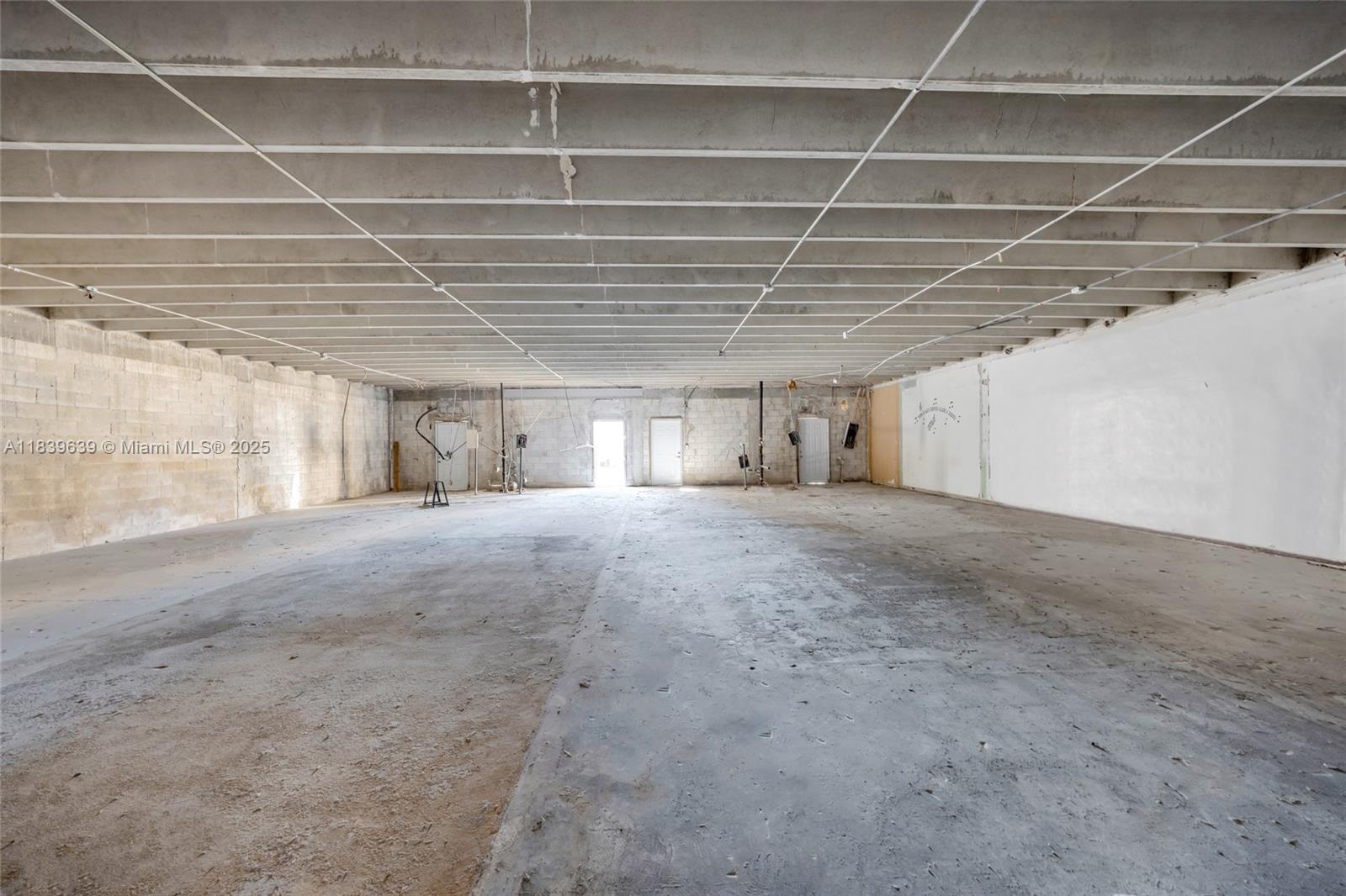 An empty, unfinished industrial warehouse space features exposed concrete ceilings and block walls — 1544 W Flagler St, Miami FL 33135, MIAMI, FL
