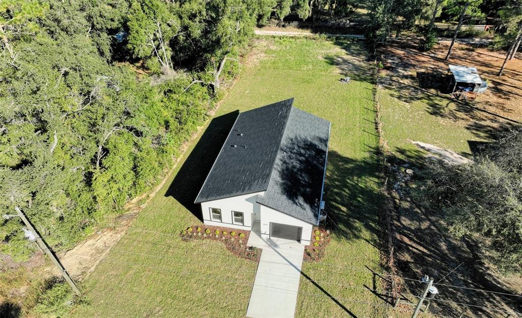 An aerial view shows a white house with a dark roof on a grassy lot — 13527 SW 100TH LANE, DUNNELLON, FL