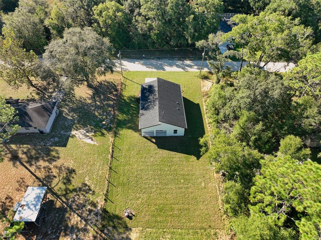 An aerial view shows a detached garage on a grassy lot surrounded by trees — 13527 SW 100TH LANE, DUNNELLON, FL