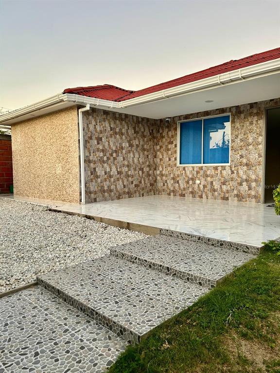 A house exterior featuring a tiled patio, stone-textured walls, and a red roof — Cra 11 #7-72, SANTA VERONICA, ATLANTICO, OC