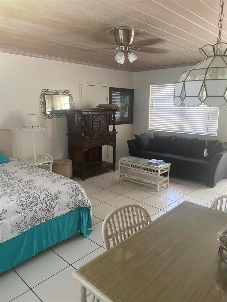 A studio apartment features a bed, a sofa, a dining table, and tile flooring — 30 Andrews Avenue # 23c, Delray Beach FL 33483, DELRAY BEACH, FL