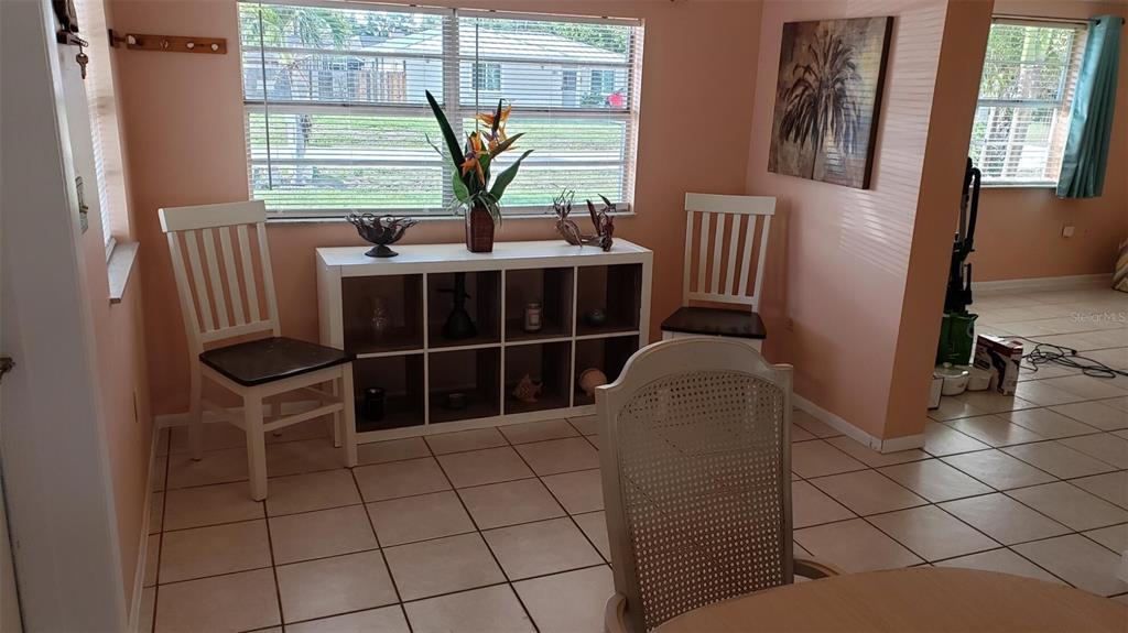A dining area features a white cube storage unit, two white chairs, and tile flooring — 375 TERRAPIN, VENICE, FL