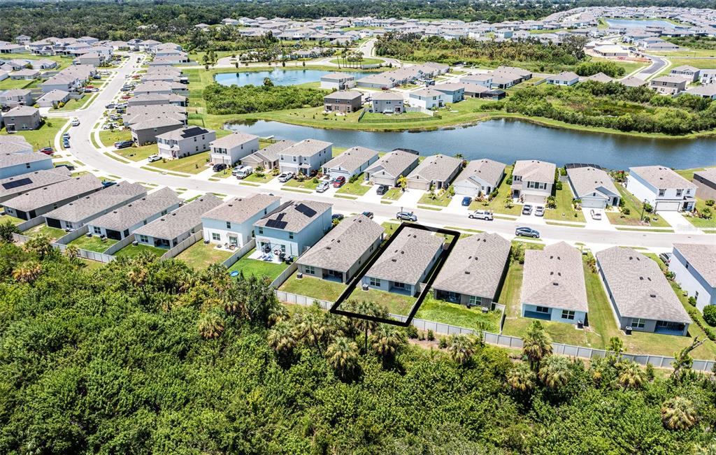 An aerial view shows a suburban neighborhood with a highlighted single-family home and backyard — 5185 ROCKY COAST PLACE, PALMETTO, FL