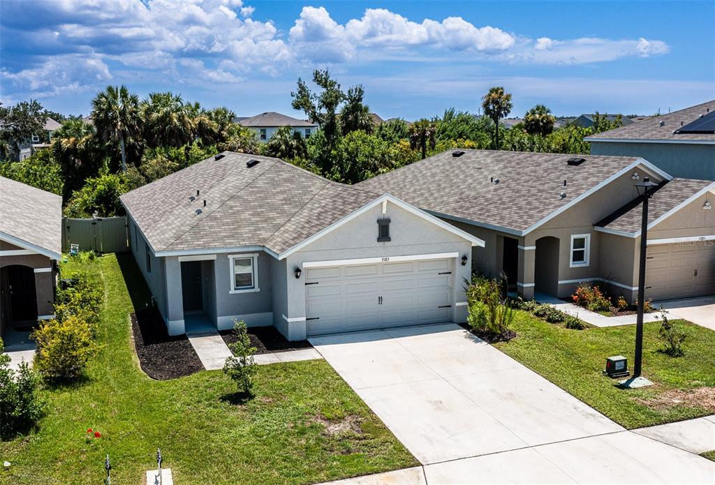 An aerial view of a single-story house with a gray exterior and a two-car garage — 5185 ROCKY COAST PLACE, PALMETTO, FL