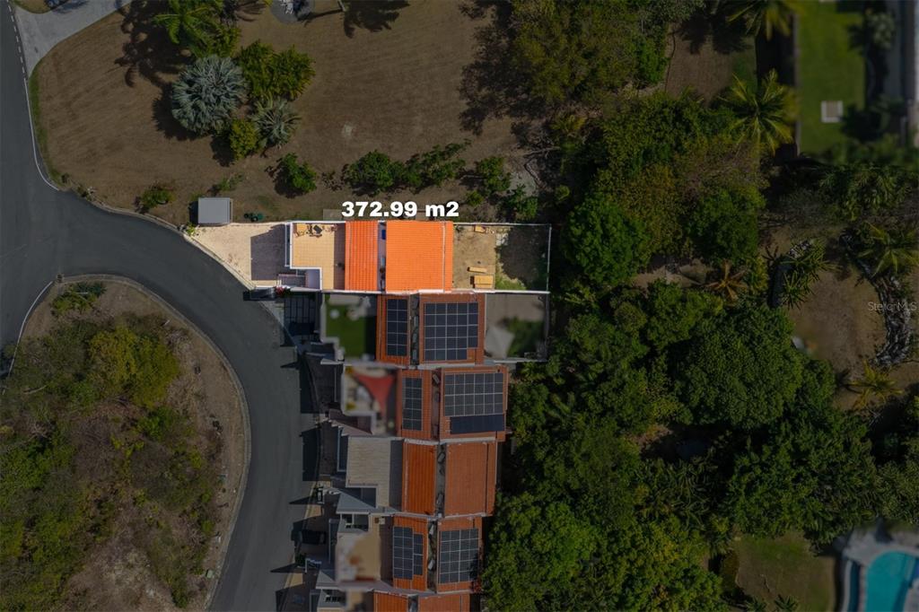 This aerial view shows a residential property with a tiled roof and solar panels — 1 SHELL CASTLE CLUB CLUB, HUMACAO, PR