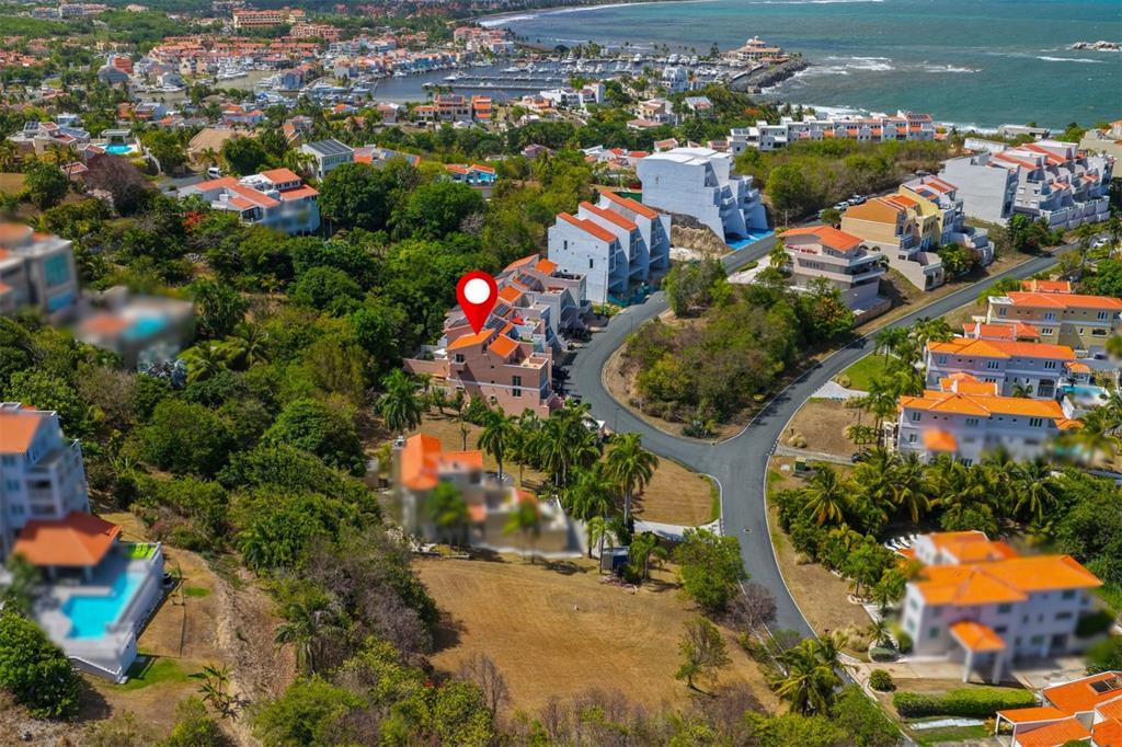An aerial view shows a multi-story residential building with a red roof near the coast — 1 SHELL CASTLE CLUB CLUB, HUMACAO, PR