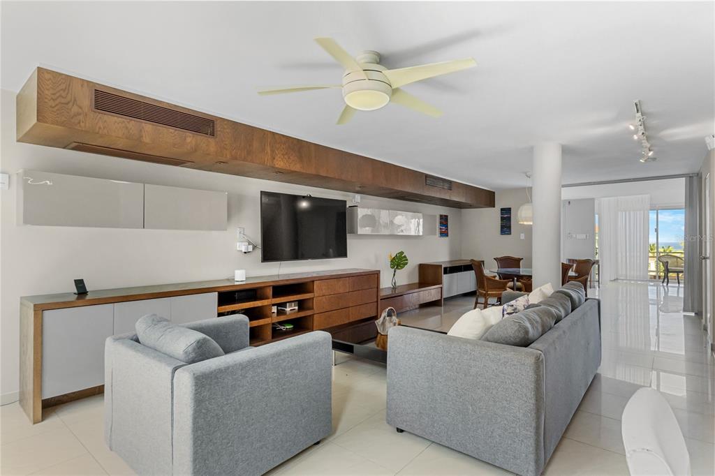 A living room features a grey sofa, armchair, wood cabinetry, and a ceiling fan — 1 SHELL CASTLE CLUB CLUB, HUMACAO, PR