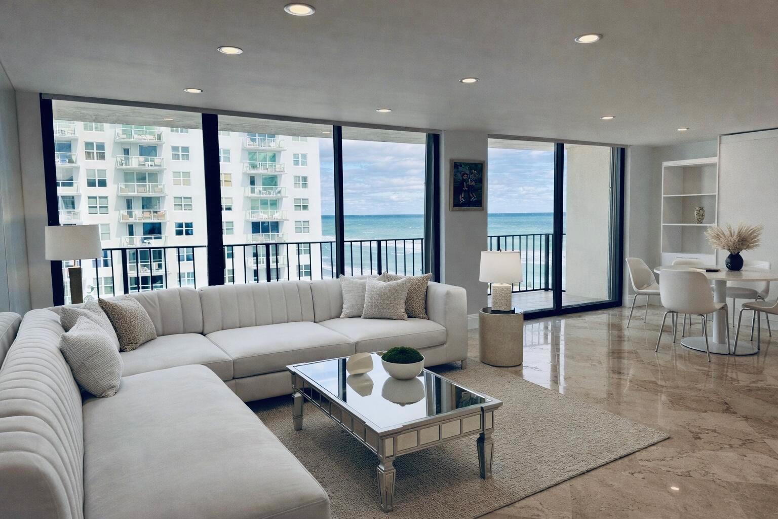 A living room with a white sectional sofa, mirrored coffee table, and ocean views — 3456 S Ocean Boulevard # 504, Palm Beach FL 33480, PALM BEACH, FL