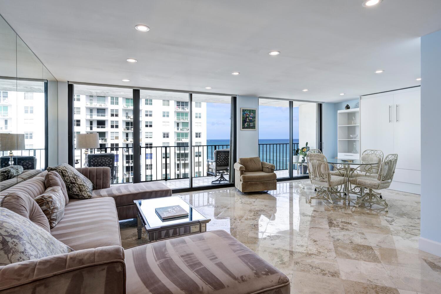 A living room with marble floors, a sectional sofa, and floor-to-ceiling windows overlooking the ocean — 3456 S Ocean Boulevard # 504, Palm Beach FL 33480, PALM BEACH, FL