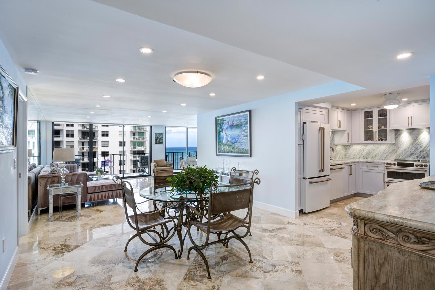 An open-concept living and dining area with marble floors, a kitchen, and ocean views — 3456 S Ocean Boulevard # 504, Palm Beach FL 33480, PALM BEACH, FL