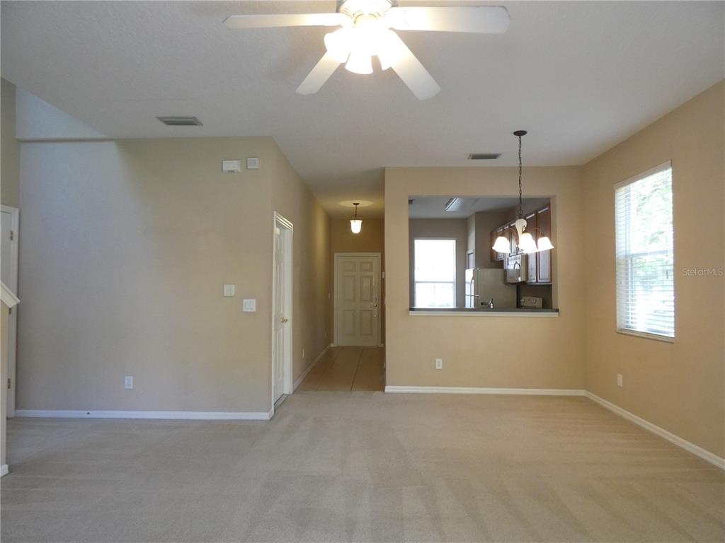 An interior view shows a carpeted living area with a ceiling fan and kitchen pass-through — 2111 RETREAT VIEW CIRCLE, SANFORD, FL