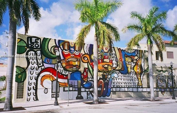 A large, colorful mural painted on the exterior wall of a building with palm trees — 2126 Arthur St # 1, Hollywood FL 33020, HOLLYWOOD, FL