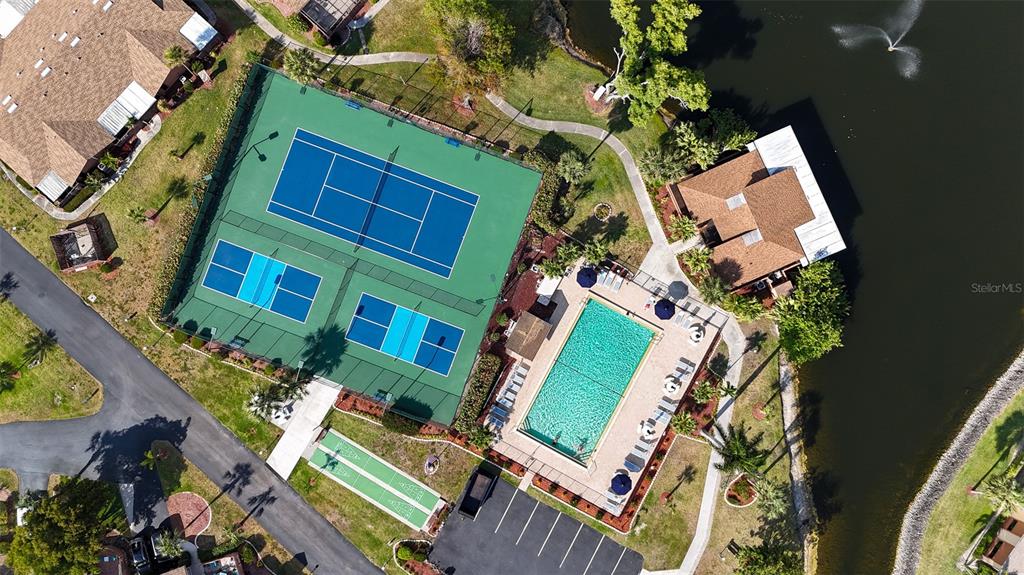 An aerial view shows a tennis court, pickleball courts, a swimming pool, and a clubhouse — 17426 BIRCHWOOD LANE UNIT 1, FORT MYERS, FL