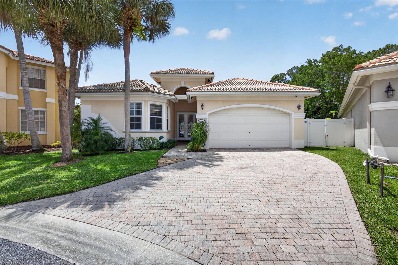 A single-story house with a tiled roof, a two-car garage, and a paved driveway — 8642 Plum Cay, Royal Palm Beach FL 33411, ROYAL PALM BEACH, FL
