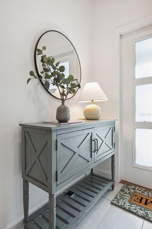A gray console table with a lamp and mirror sits in an entryway — 2440 READING TRAIL, KISSIMMEE, FL