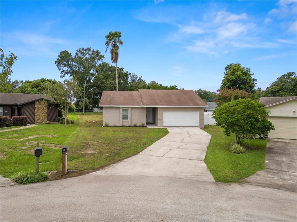 A single-story tan house with a white garage door and a concrete driveway — 3664 WILLOW WISP DRIVE S, LAKELAND, FL
