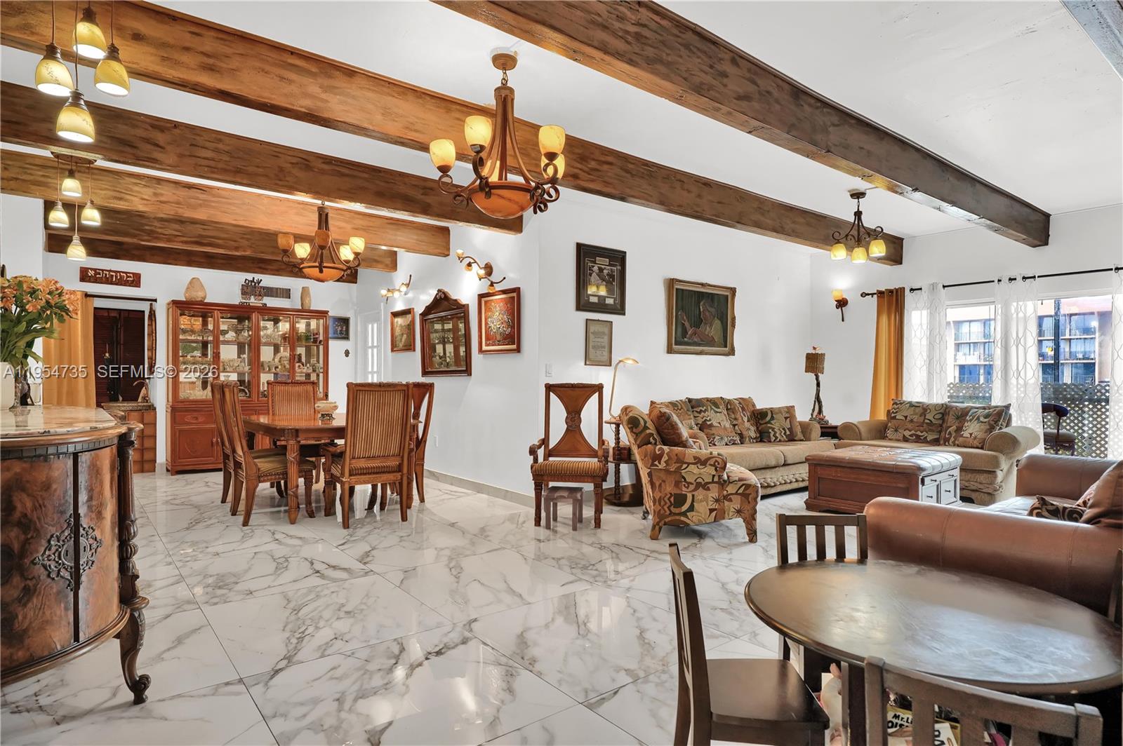 A spacious living and dining area features white marble floors and exposed wooden ceiling beams — 16750 NE 10th Ave, North Miami Beach FL 33162, NORTH MIAMI BEACH, FL