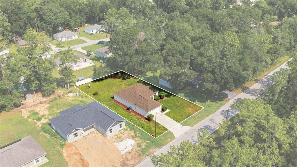 An aerial view shows a single-story house with a brown roof on a grassy lot — 5522 NW 60TH TERRACE, OCALA, FL