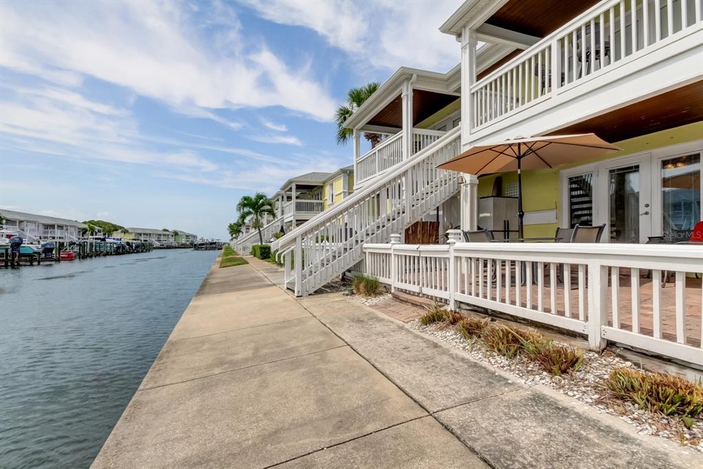 An aerial view shows a waterfront residential complex with a canal, boat slips, and parking — 5092 BEACH DRIVE SE UNIT A, ST PETERSBURG, FL