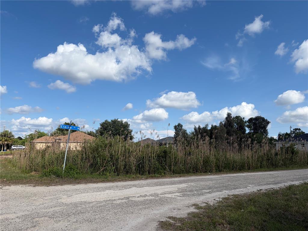 A vacant, cleared lot with a pile of sand sits in front of nearby houses — 2619 26TH STREET W, LEHIGH ACRES, FL
