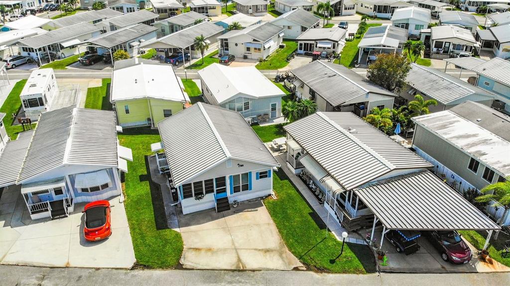 An aerial view shows several manufactured homes with metal roofs and carports in a community — 3333 26TH AVENUE E UNIT 1099, BRADENTON, FL