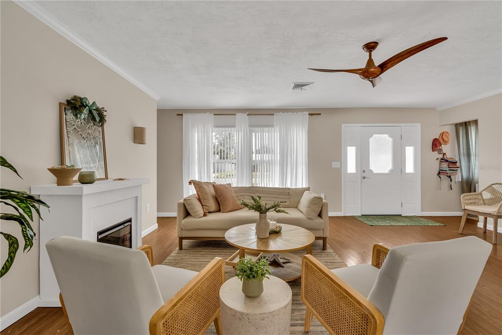 A living room features a fireplace, a sofa, two armchairs, and a ceiling fan — 2449 BREAKWATER CIRCLE, SARASOTA, FL