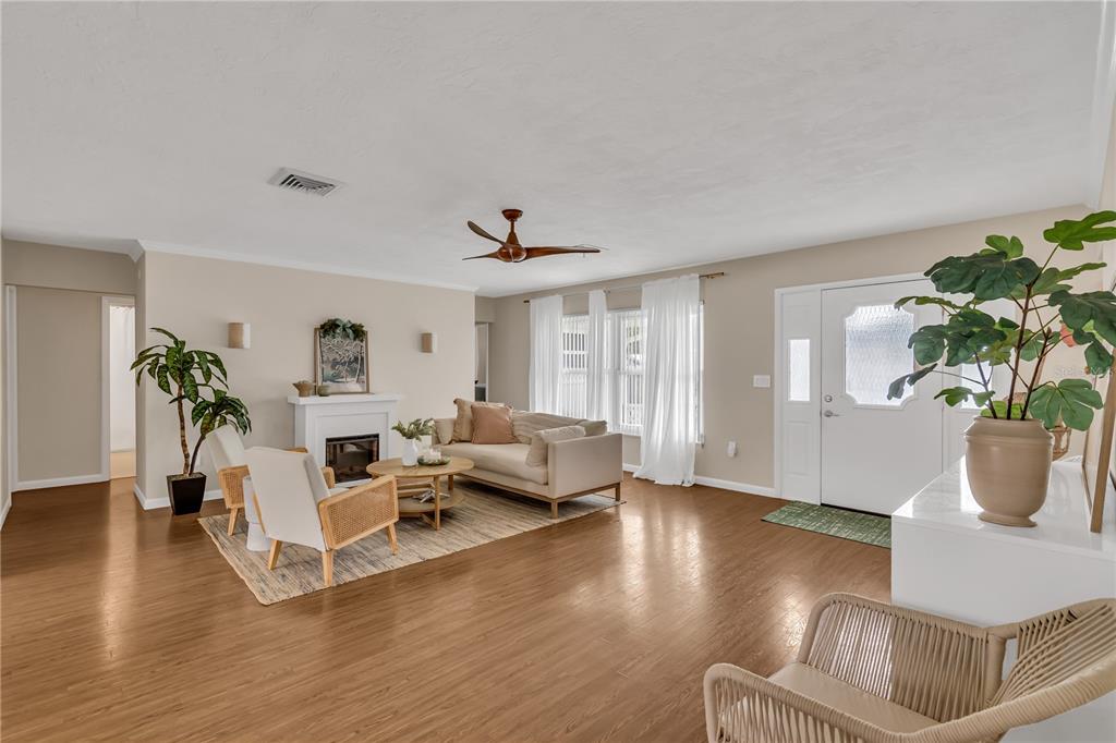A bright living room features hardwood floors, a fireplace, a sofa, and a ceiling fan — 2449 BREAKWATER CIRCLE, SARASOTA, FL