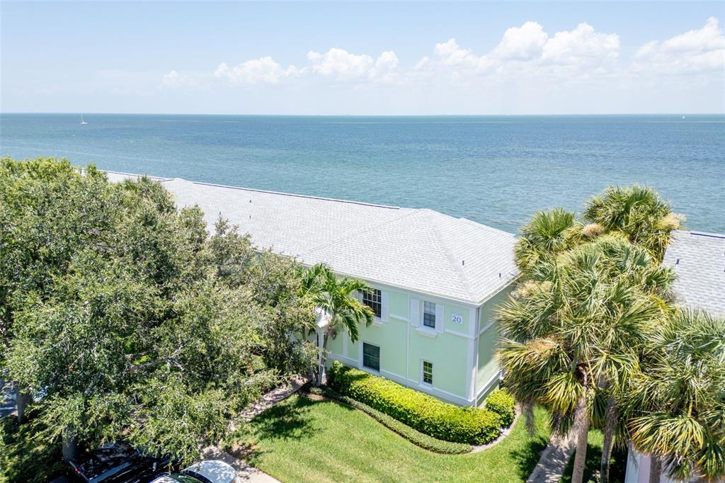 An aerial view of a light green two-story building situated along a waterfront — 5118 COQUINA KEY DRIVE SE UNIT C, ST PETERSBURG, FL