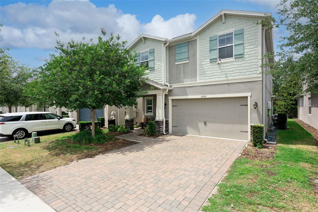 A two-story house with a paved driveway, a two-car garage, and light green siding — 2265 EMERALD SPRINGS DRIVE, APOPKA, FL