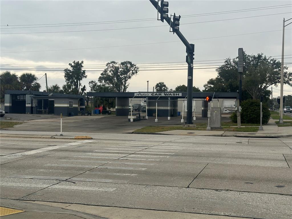 A street-level view of a car wash facility with a gray structure and signage — 1605 W MEMORIAL BOULEVARD, LAKELAND, FL