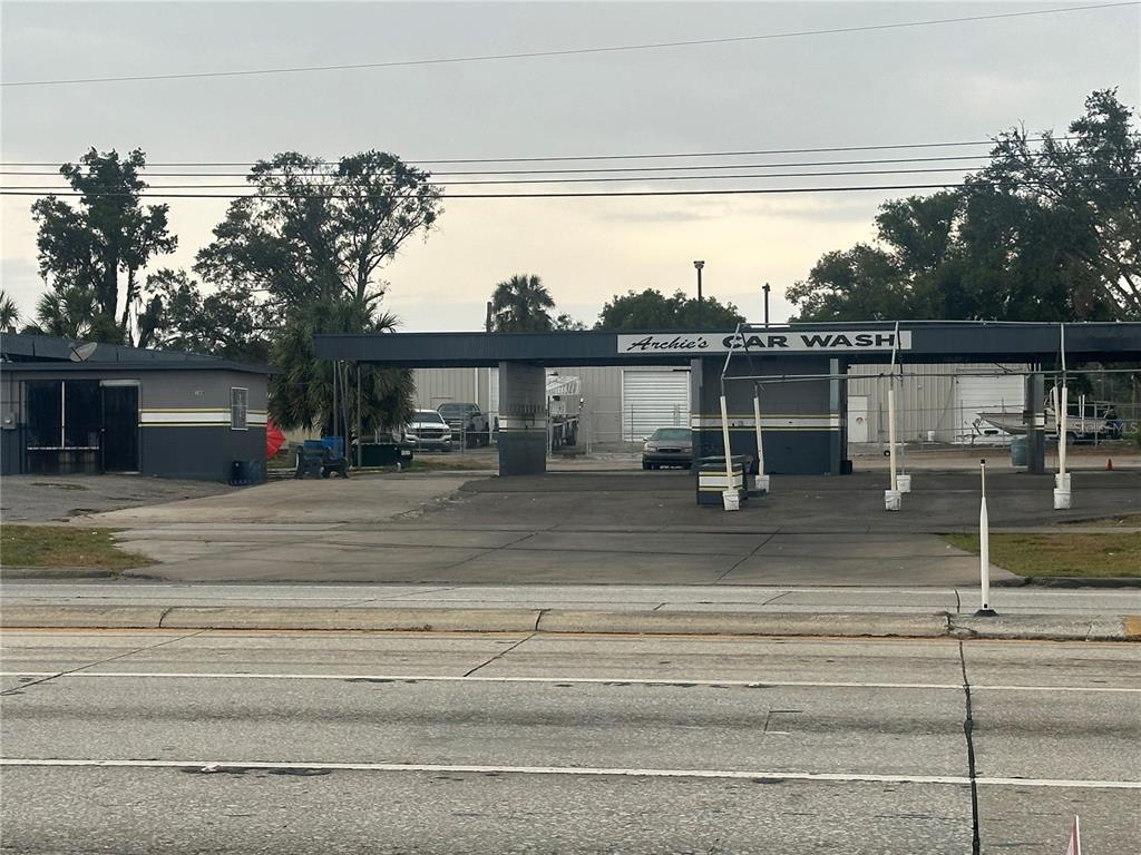 An exterior view of a car wash facility with a paved lot and metal canopy — 1605 W MEMORIAL BOULEVARD, LAKELAND, FL