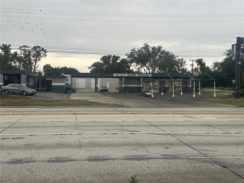 A street-level view of a commercial car wash facility with a paved parking area — 1605 W MEMORIAL BOULEVARD, LAKELAND, FL