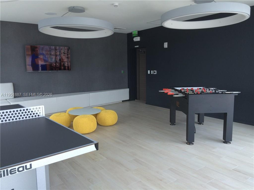 A game room features a foosball table, a ping pong table, and yellow ottoman seating — 1100 S Miami Ave # 2111, Miami FL 33130, MIAMI, FL