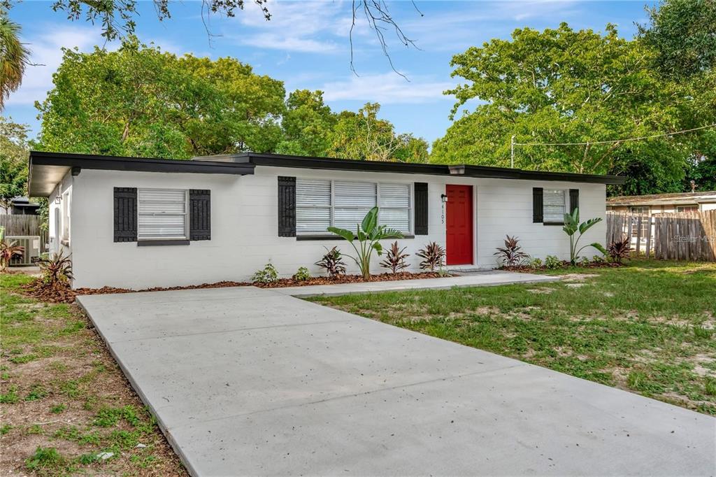 A single-story white house with a red front door and a concrete driveway — 4105 W MANGO AVENUE, TAMPA, FL