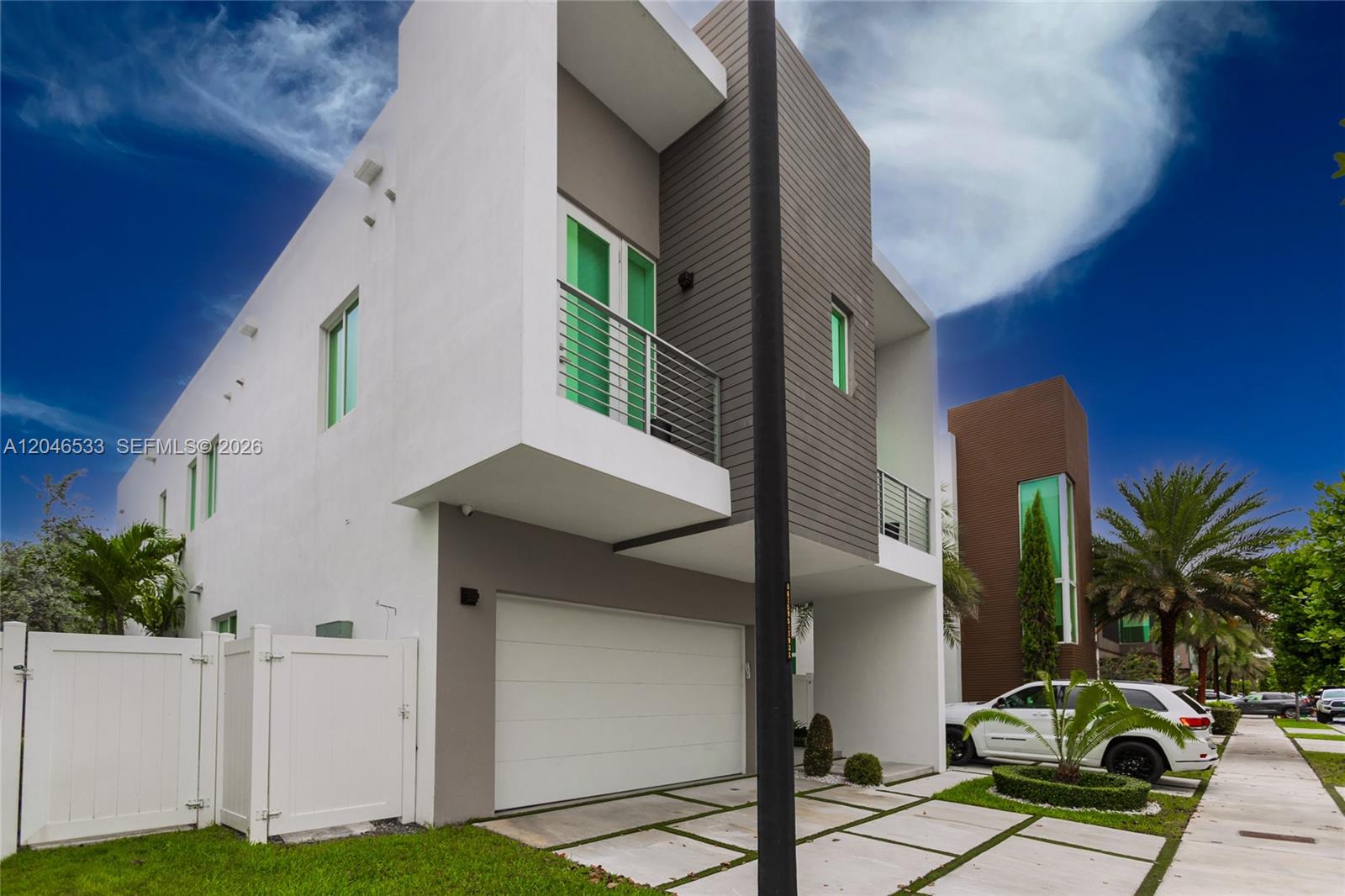 A modern two-story house with a white facade, gray siding, and a garage — 10561 NW 68th Ter, Doral FL 33178, DORAL, FL