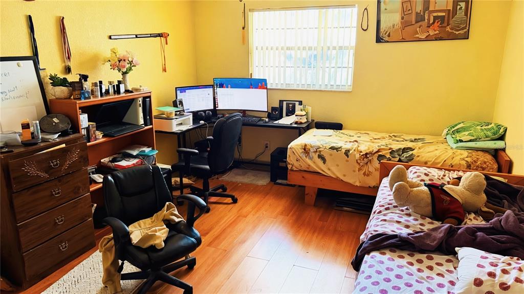 A bedroom features two beds, a computer desk with monitors, and a wooden dresser — 2515 W POWHATAN AVENUE, TAMPA, FL