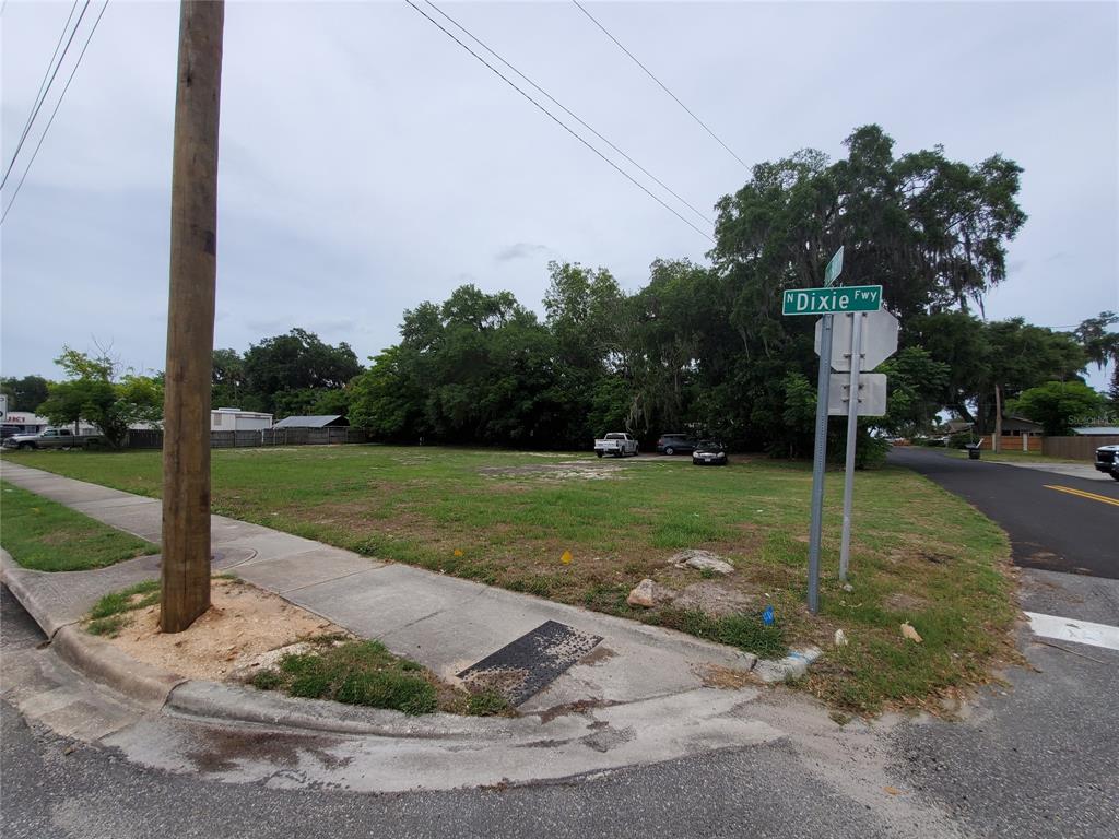 A vacant, grassy corner lot features a utility pole and a street sign — 903 N DIXIE FREEWAY, NEW SMYRNA BEACH, FL