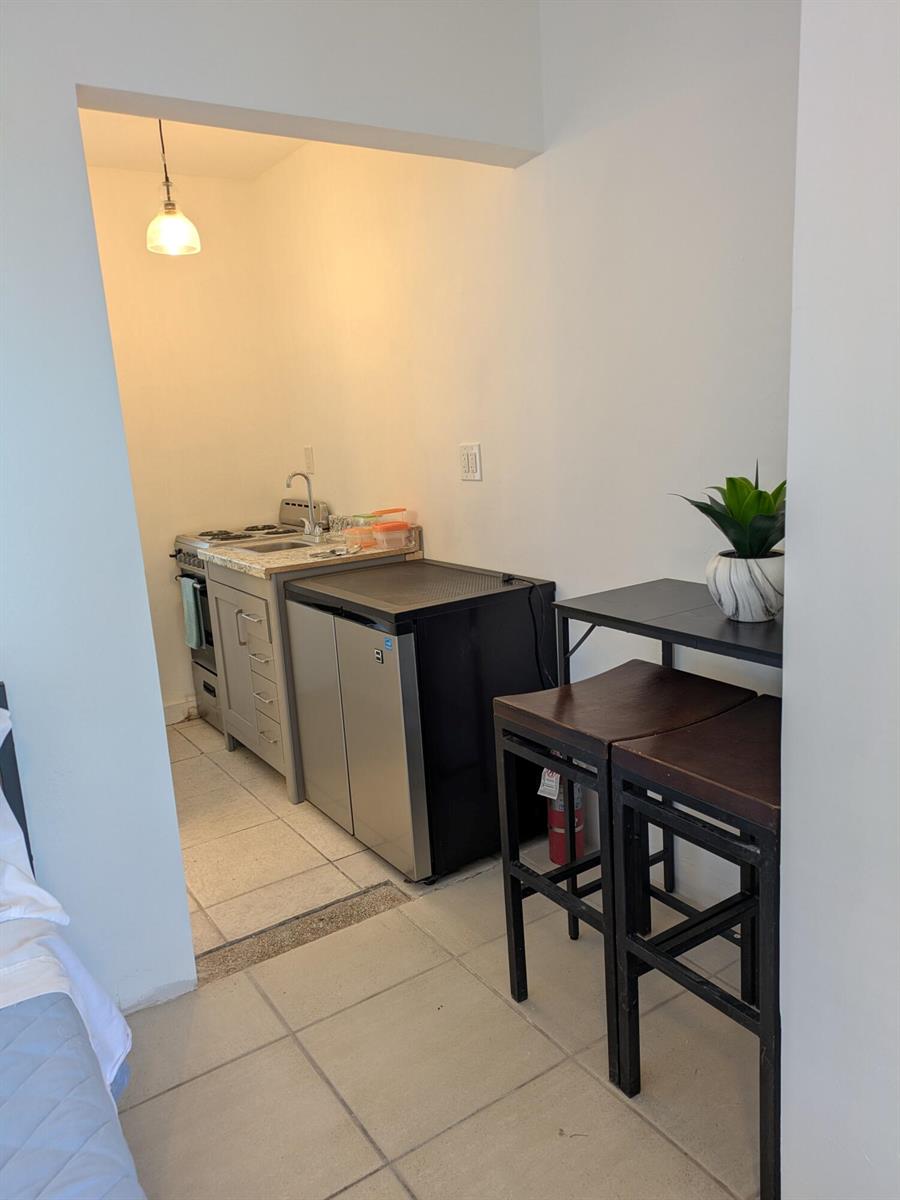 A small kitchenette features a stove, sink, mini-fridge, and a two-seat dining table — 3312 SE 4th Street # 3, Pompano Beach FL 33062, POMPANO BEACH, FL