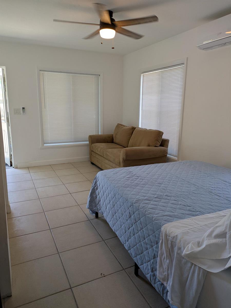 A bedroom with tile flooring, a ceiling fan, a bed, and a small brown sofa — 3312 SE 4th Street # 3, Pompano Beach FL 33062, POMPANO BEACH, FL