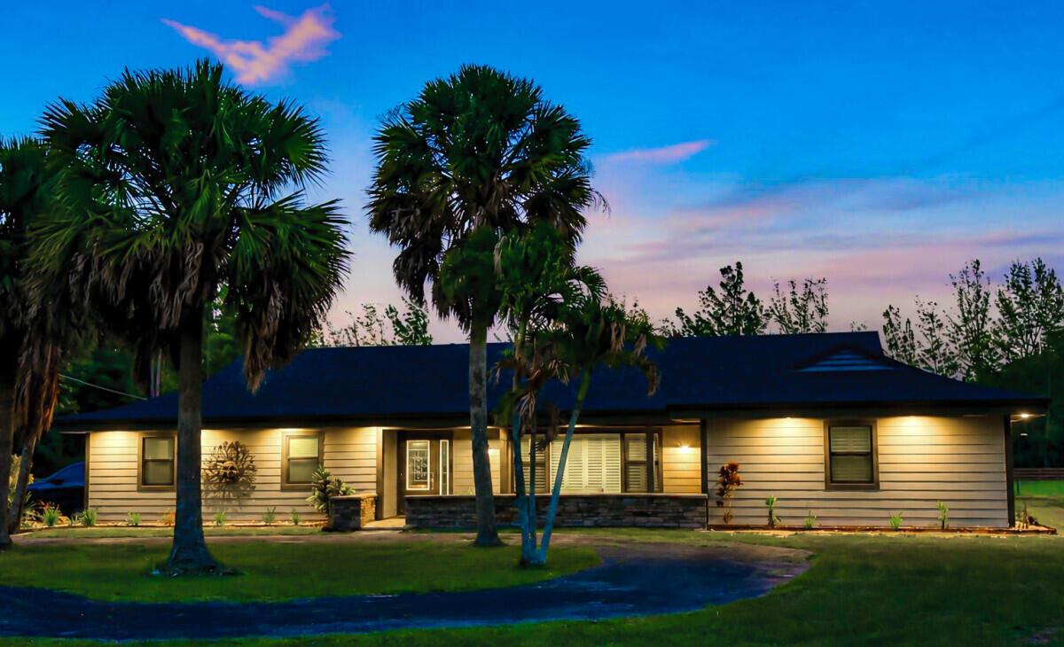 A single-story house with horizontal siding and palm trees at dusk — 1464 Clydesdale Drive, FL 33470, FL