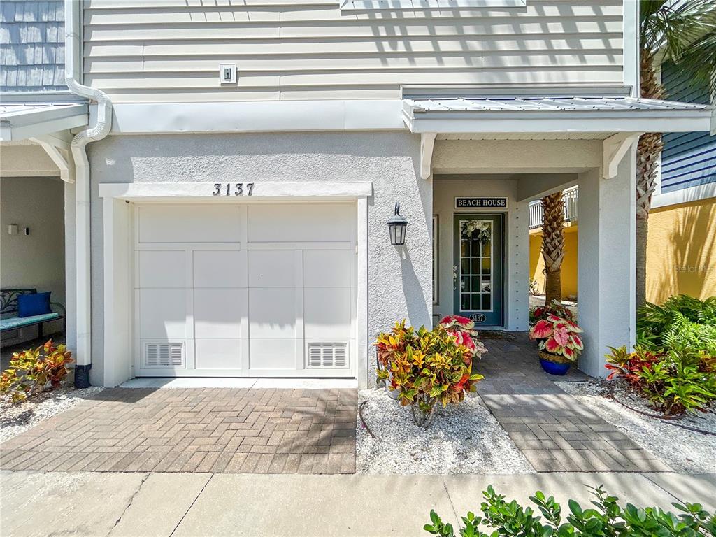 A white garage door and a teal front door with a beach house sign — 3137 MOORINGS DRIVE S, ST PETERSBURG, FL