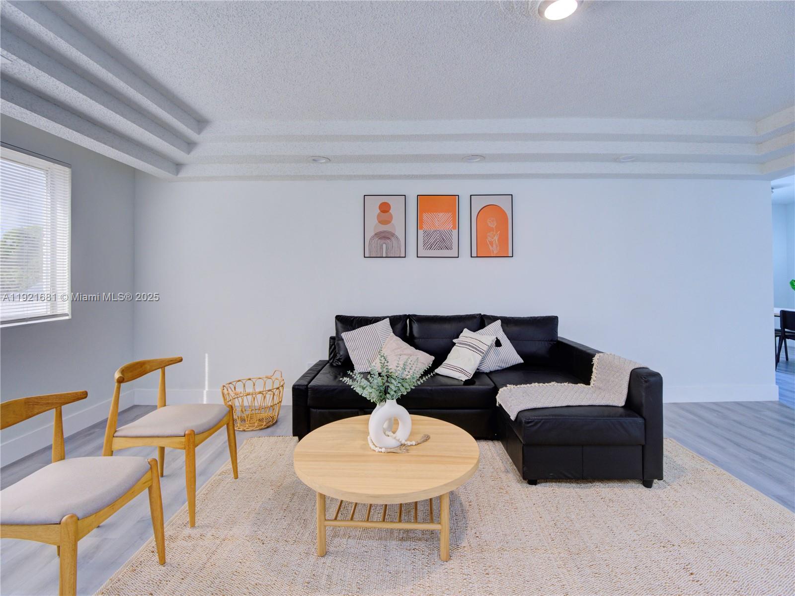 A living room features a black sectional sofa, a round wooden coffee table, and two chairs — 2703 Adams St, Hollywood FL 33020, HOLLYWOOD, FL