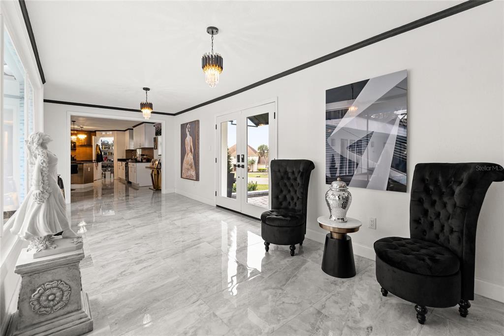 A bright foyer features marble floors, two black tufted chairs, and a white statue — 5701 TARAWOOD DRIVE, ORLANDO, FL