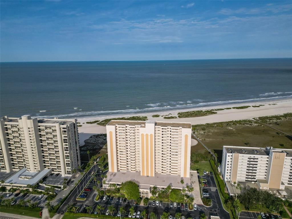 An aerial view of three high-rise apartment buildings situated along a sandy beach and ocean — 1270 GULF BOULEVARD UNIT 1706, CLEARWATER BEACH, FL
