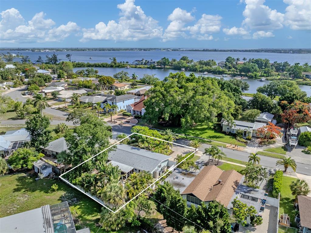 An aerial view shows a residential house with a gray roof surrounded by lush landscaping — 632 PARK DRIVE, BRADENTON, FL