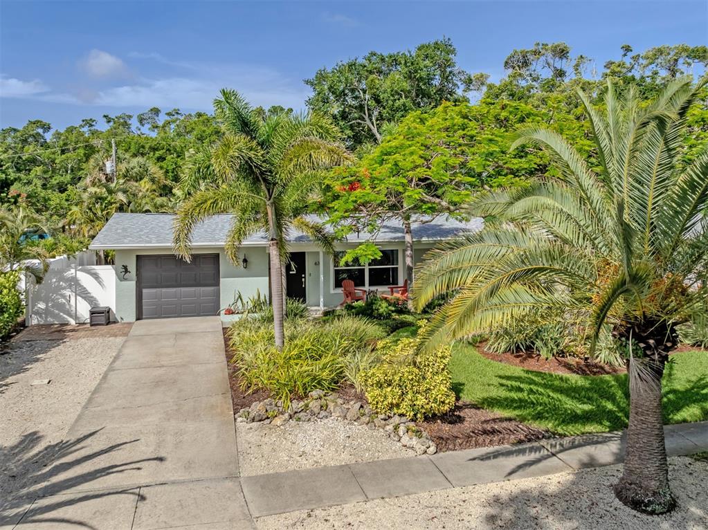 A single-story house with a concrete driveway, palm trees, and a landscaped front yard — 632 PARK DRIVE, BRADENTON, FL