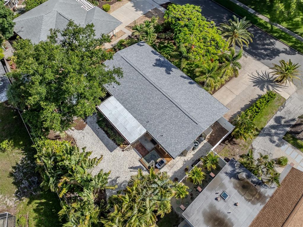 An aerial view shows a house with a gray shingled roof surrounded by lush landscaping — 632 PARK DRIVE, BRADENTON, FL
