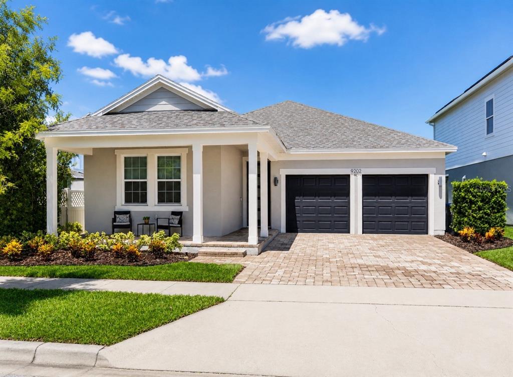 A single-story house with a gray exterior, a front porch, and a two-car garage — 9202 MERLON DRIVE, WINTER GARDEN, FL