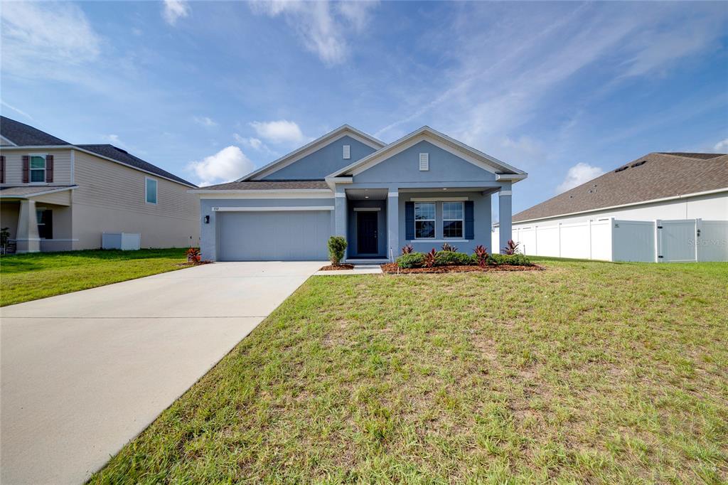 A single-story blue house with a two-car garage and a concrete driveway — 352 BRIARBROOK LANE, HAINES CITY, FL
