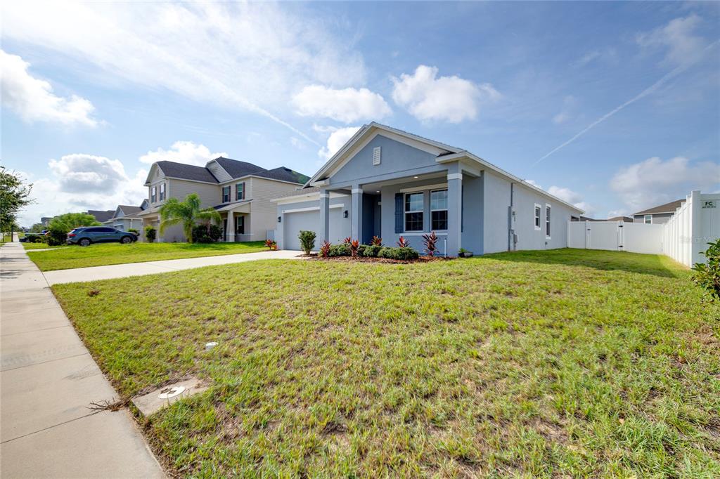 A single-story light blue house with a front porch, garage, and a grassy front yard — 352 BRIARBROOK LANE, HAINES CITY, FL